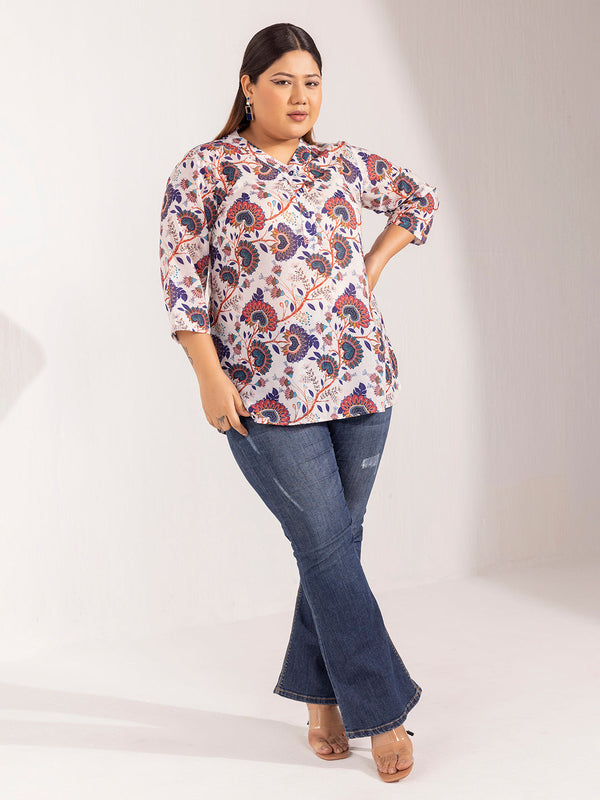 Plus-size model wearing a stylish V-neck printed top and jeans.