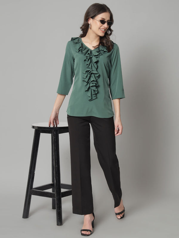 Green ruffled neckline top paired with black pants, stylish look.