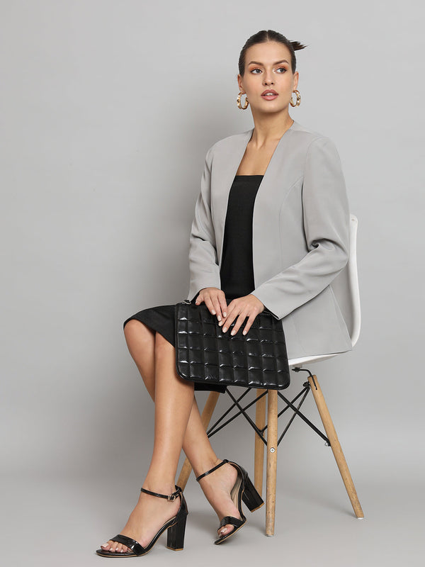 Lapel less stretch blazer in grey worn with black dress and accessories.