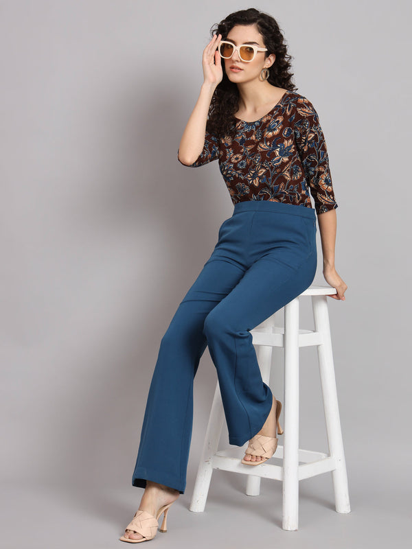 Floral cotton top in brown, styled with blue pants and accessories.