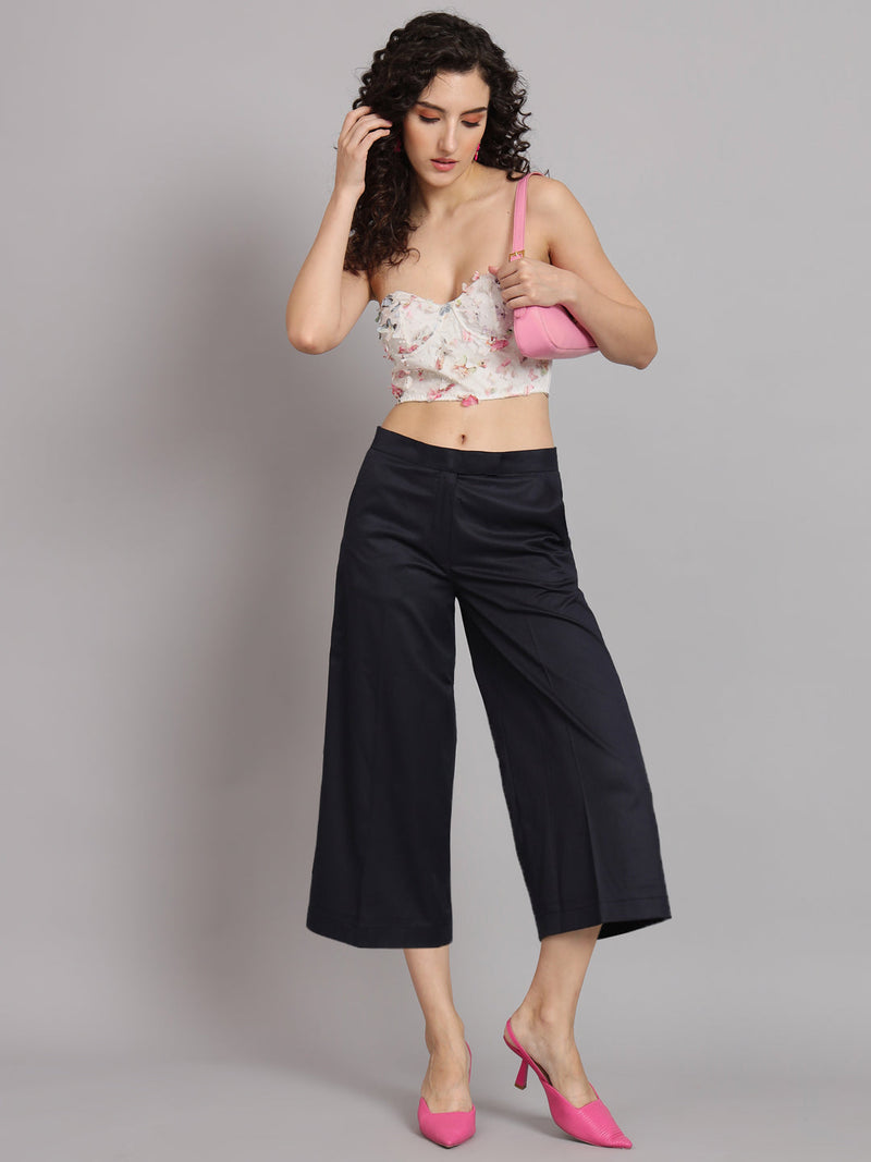 Model wearing navy blue poly cotton mid waist culottes with a floral top.