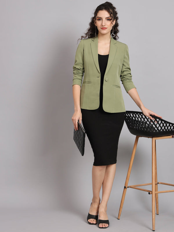 Olive green notched collar blazer styled with black dress and accessories.