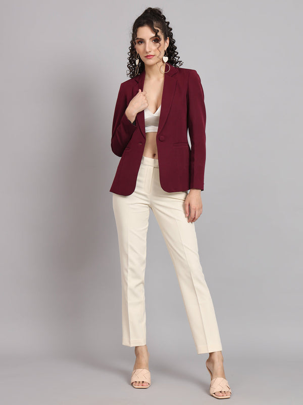 Maroon notched collar blazer styled with cream trousers for women.