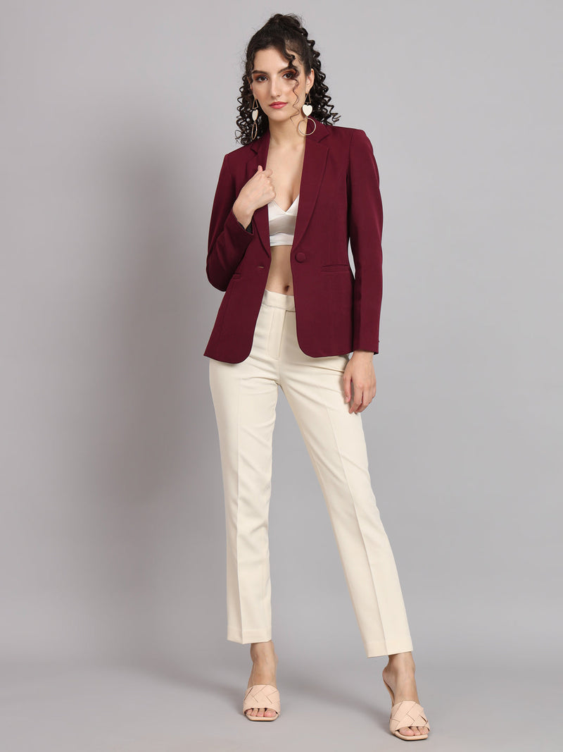 Maroon notched collar blazer styled with cream trousers for women.