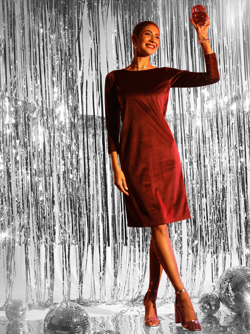 Maroon stretch velvet dress on model celebrating with a drink.