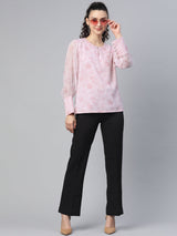 Chiffon floral print top in baby pink worn with stylish pants.