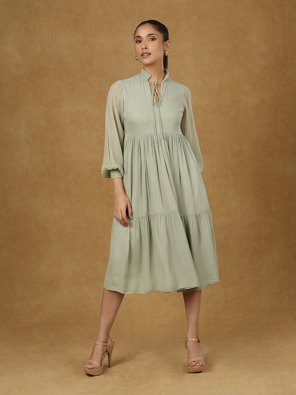 Olive solid tiered dress with long sleeves and elegant silhouette.