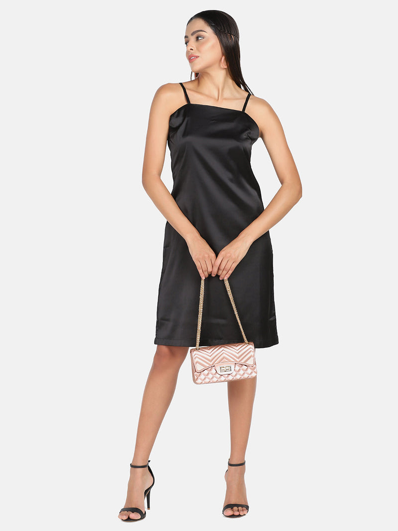 Satin spaghetti dress in black with stylish handbag and heels.