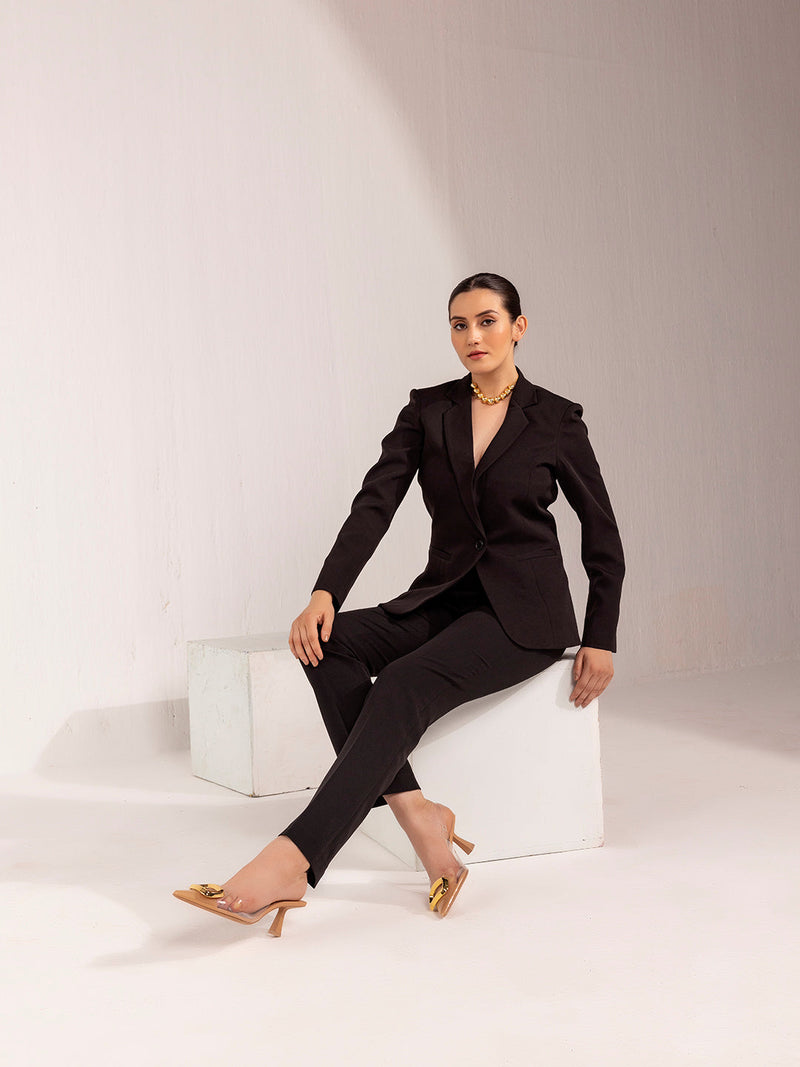 Elegant woman wearing a black stretch pant suit with heels.